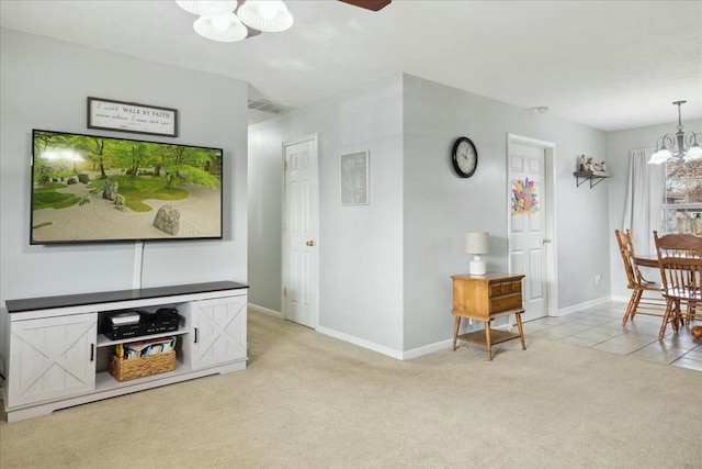 carpeted living room with ceiling fan with notable chandelier