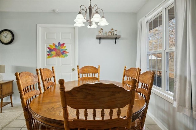 tiled dining room featuring an inviting chandelier