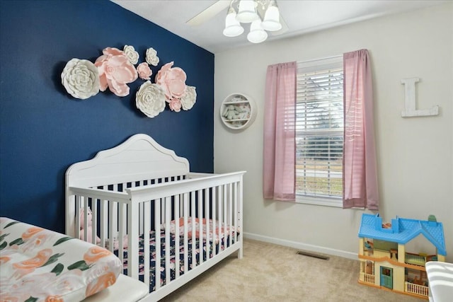 carpeted bedroom with a nursery area and ceiling fan