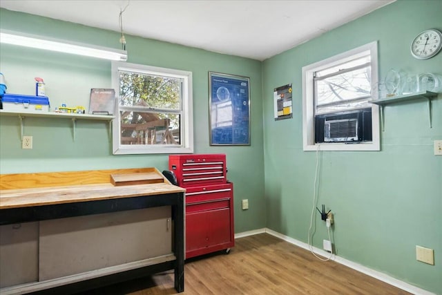 misc room featuring a healthy amount of sunlight, light wood-type flooring, and cooling unit