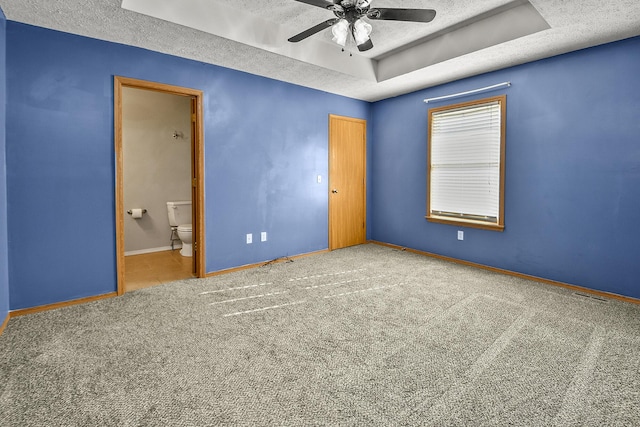 unfurnished bedroom with connected bathroom, ceiling fan, carpet, and a textured ceiling