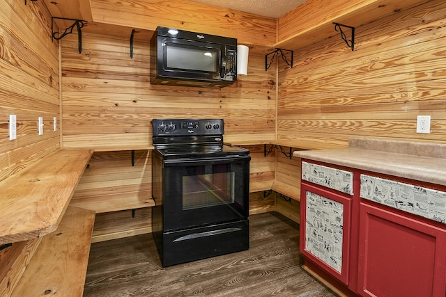 kitchen featuring wooden walls, dark hardwood / wood-style flooring, and black appliances