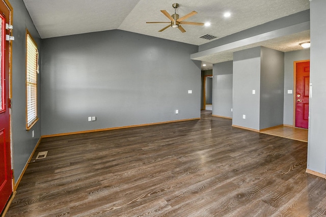 spare room featuring a textured ceiling, lofted ceiling, ceiling fan, and dark hardwood / wood-style floors