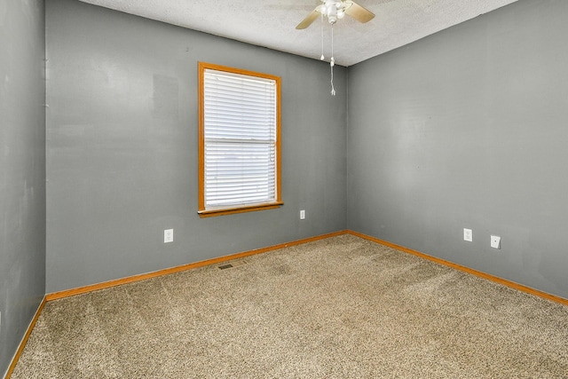 carpeted empty room with ceiling fan and a textured ceiling