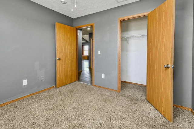 unfurnished bedroom featuring carpet, a textured ceiling, and a closet