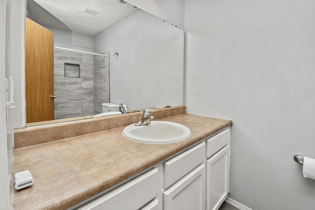 bathroom with vanity, toilet, and a shower