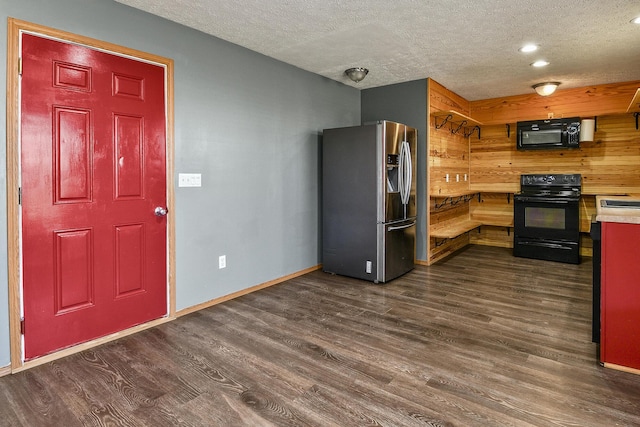 kitchen with black appliances, dark wood-type flooring, and a textured ceiling