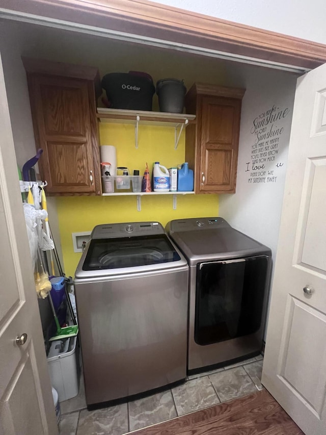 clothes washing area featuring cabinets and independent washer and dryer