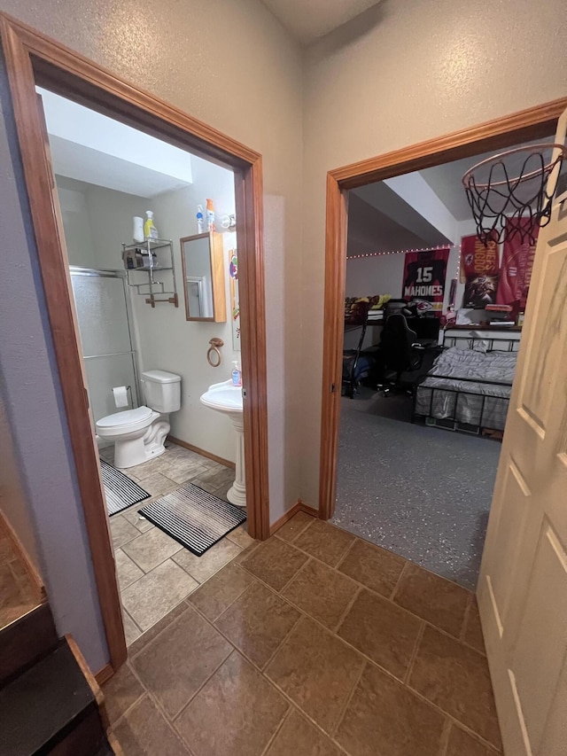 bathroom with toilet and a shower with shower door