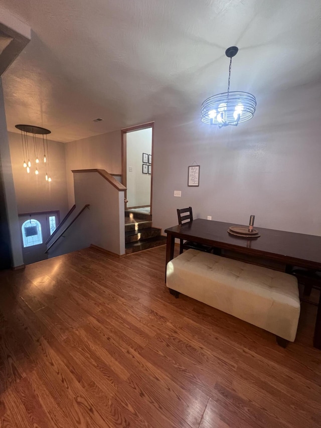 unfurnished dining area featuring wood-type flooring and an inviting chandelier