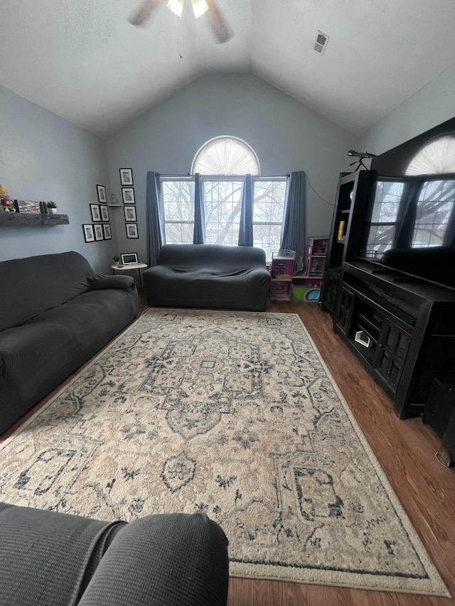 living room with dark wood-type flooring, ceiling fan, and vaulted ceiling