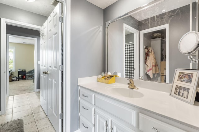 bathroom featuring tile patterned flooring, vanity, and a textured ceiling