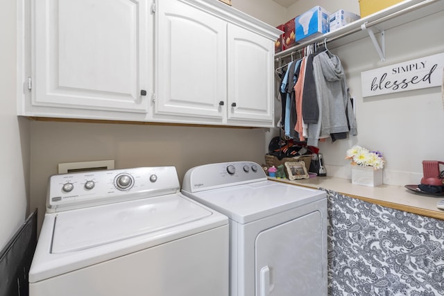 clothes washing area featuring cabinets and washing machine and clothes dryer