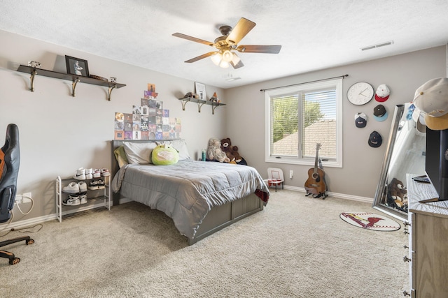 carpeted bedroom featuring ceiling fan and a textured ceiling