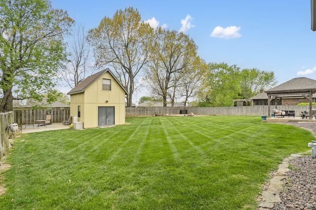 view of yard featuring a fenced backyard, an outbuilding, a gazebo, and a patio