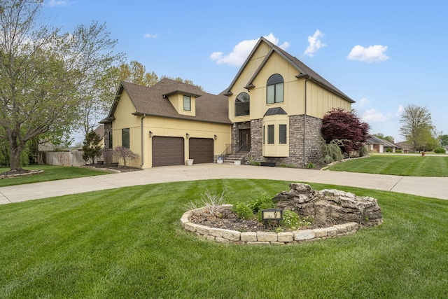 view of front of property featuring a front lawn, driveway, stone siding, fence, and stucco siding