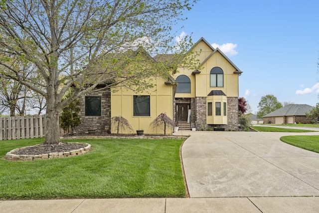 view of front of property with stucco siding, stone siding, a front lawn, and fence
