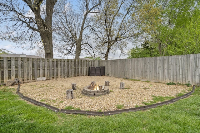 view of yard featuring a fire pit and a fenced backyard