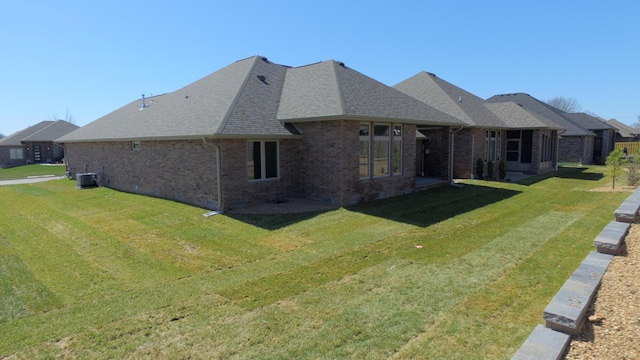 2423 E Cardinal St, Springfield, MO 65804 - exterior space with a shingled roof, a yard, brick siding, and central AC unit