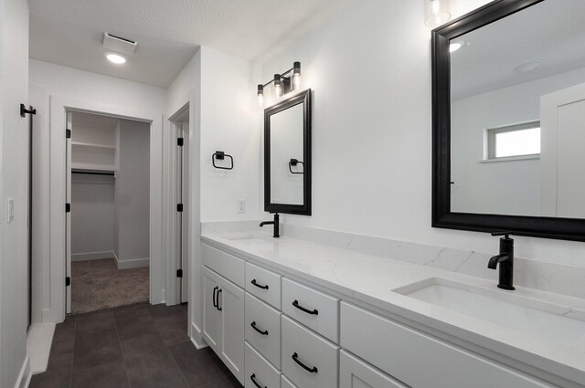 2423 E Cardinal St, Springfield, MO 65804 - bathroom with tile patterned floors, double vanity, a sink, and a walk in closet