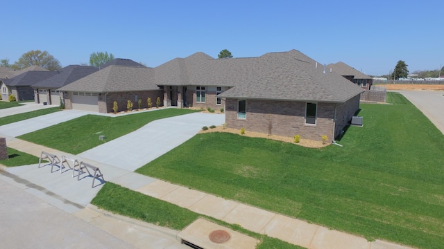 2423 E Cardinal St, Springfield, MO 65804 - ranch-style home featuring a front yard, a garage, brick siding, driveway, and roof with shingles