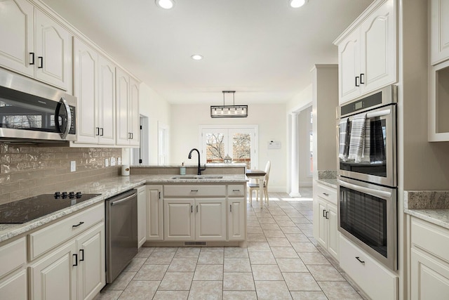 kitchen featuring pendant lighting, sink, white cabinetry, and stainless steel appliances