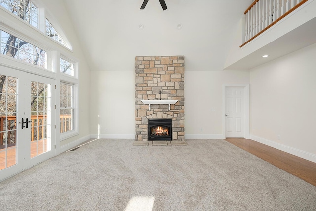 unfurnished living room featuring ceiling fan, carpet floors, a fireplace, and high vaulted ceiling