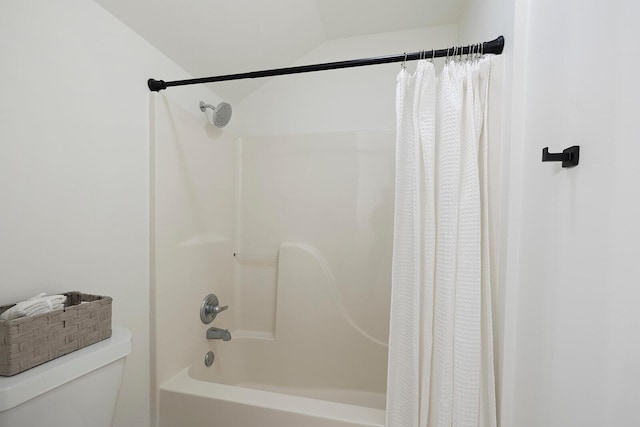 bathroom with shower / bath combination with curtain, toilet, and lofted ceiling