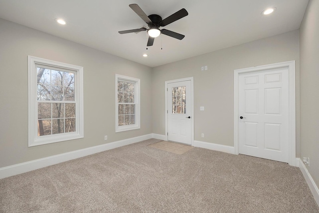 spare room with light colored carpet and ceiling fan