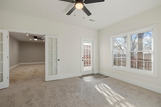 unfurnished room with light carpet, french doors, and ceiling fan