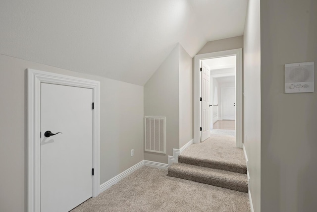 stairway featuring carpet and lofted ceiling