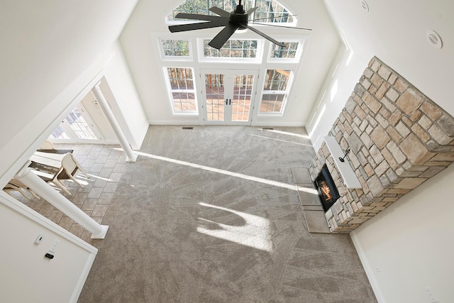 unfurnished living room featuring plenty of natural light, a towering ceiling, and carpet floors