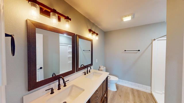 bathroom with a shower, wood-type flooring, vanity, and toilet