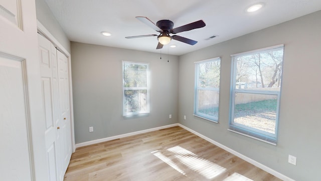 unfurnished bedroom featuring ceiling fan, light hardwood / wood-style floors, and a closet