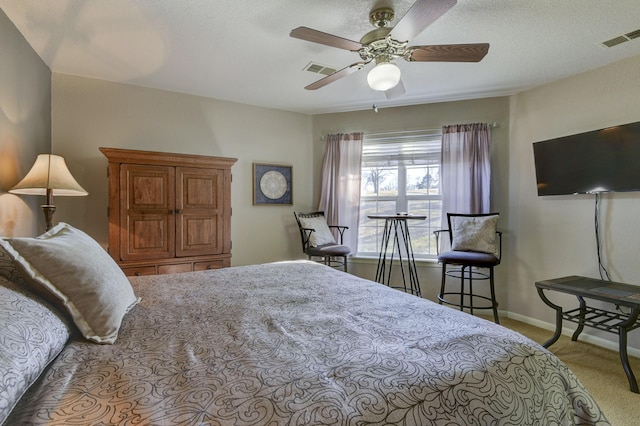 carpeted bedroom featuring ceiling fan and a textured ceiling