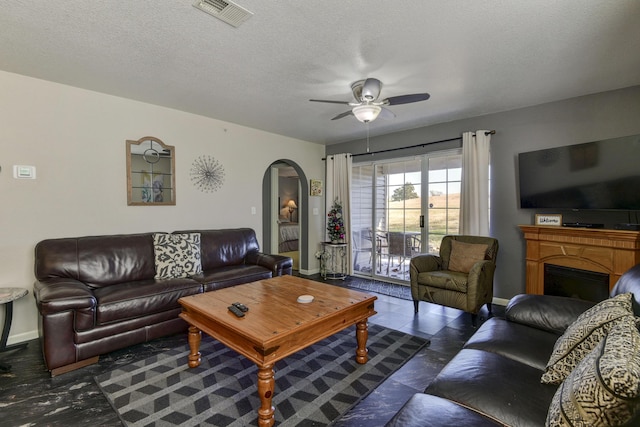 living room featuring a textured ceiling and ceiling fan