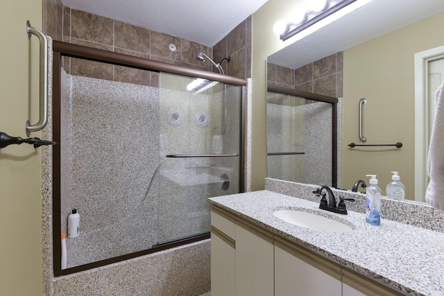 bathroom featuring vanity and a shower with door