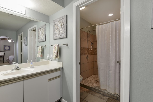 bathroom featuring tile patterned flooring, a shower with curtain, vanity, and toilet