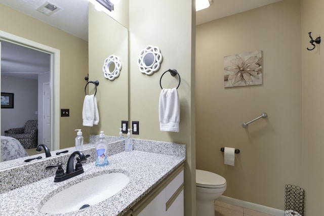 bathroom featuring tile patterned floors, vanity, and toilet