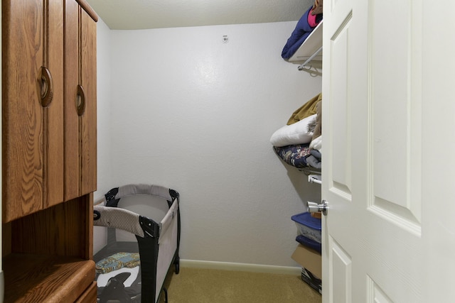 walk in closet featuring light colored carpet