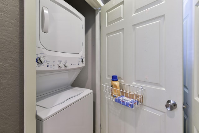 clothes washing area featuring stacked washer and clothes dryer