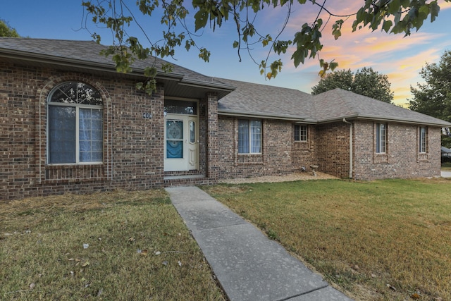 single story home with a lawn