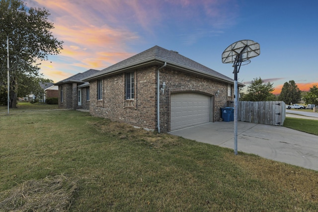 property exterior at dusk featuring a garage and a lawn