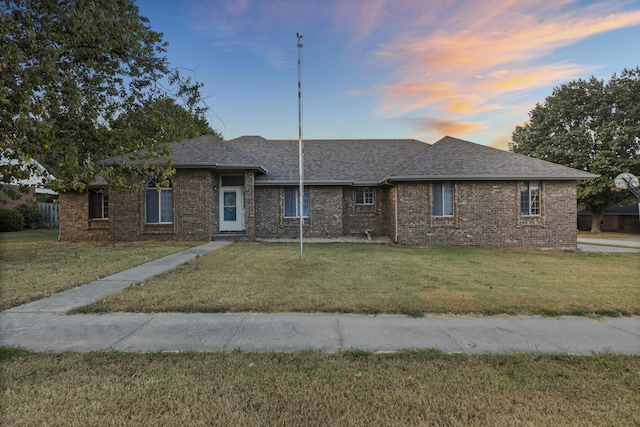 single story home with a lawn