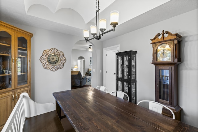 dining area featuring ceiling fan with notable chandelier and lofted ceiling