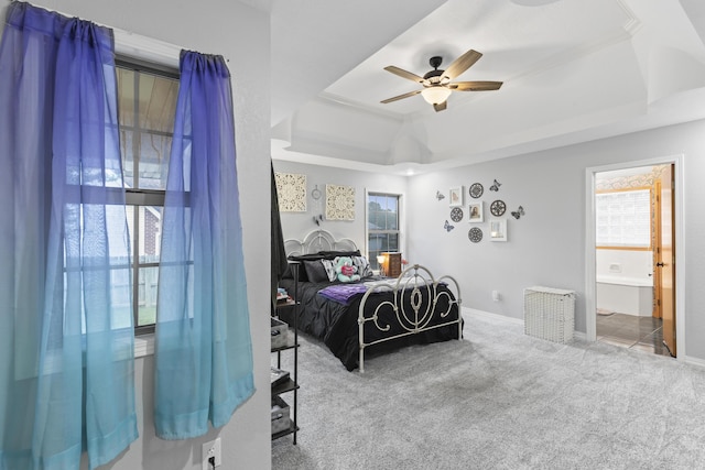 bedroom with carpet, a raised ceiling, ensuite bath, ceiling fan, and ornamental molding