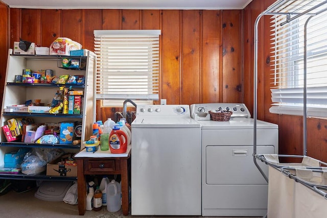 clothes washing area with separate washer and dryer and wooden walls