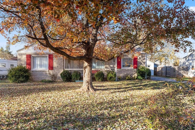 view of property hidden behind natural elements featuring a front yard