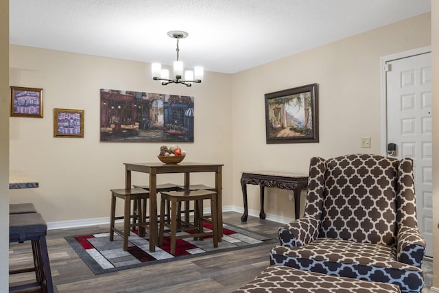 dining area featuring a textured ceiling, a chandelier, and dark hardwood / wood-style floors