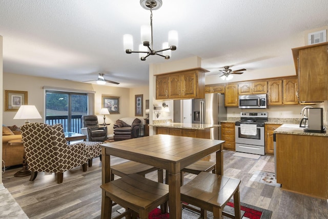 dining room featuring a textured ceiling, ceiling fan with notable chandelier, wood-type flooring, and sink